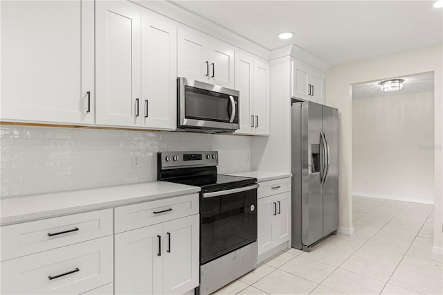 kitchen with white cabinetry, decorative backsplash, light tile patterned floors, and stainless steel appliances