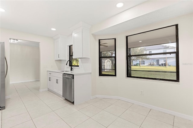 kitchen featuring sink, stainless steel appliances, light tile patterned floors, and white cabinets