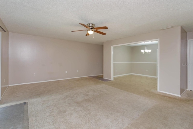 spare room with ceiling fan with notable chandelier, light colored carpet, and a textured ceiling