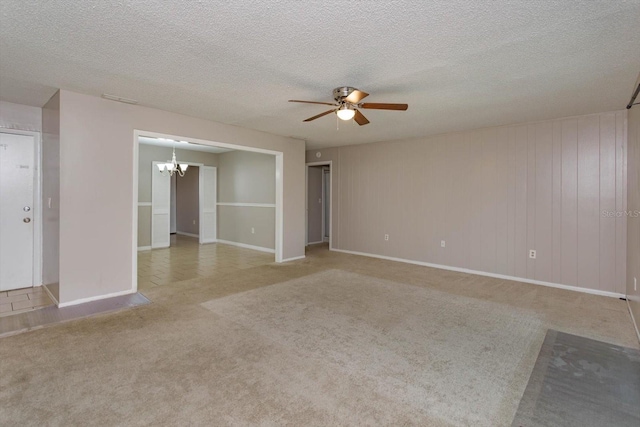 spare room with ceiling fan with notable chandelier, light colored carpet, and a textured ceiling