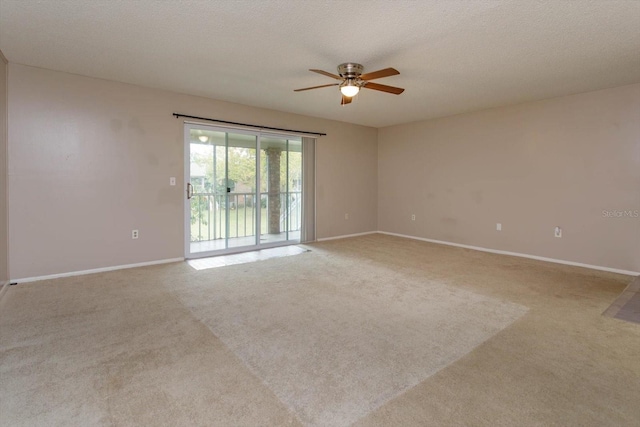 carpeted spare room with ceiling fan and a textured ceiling