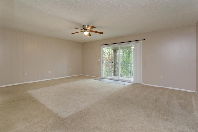 unfurnished room with ceiling fan, light carpet, and a textured ceiling