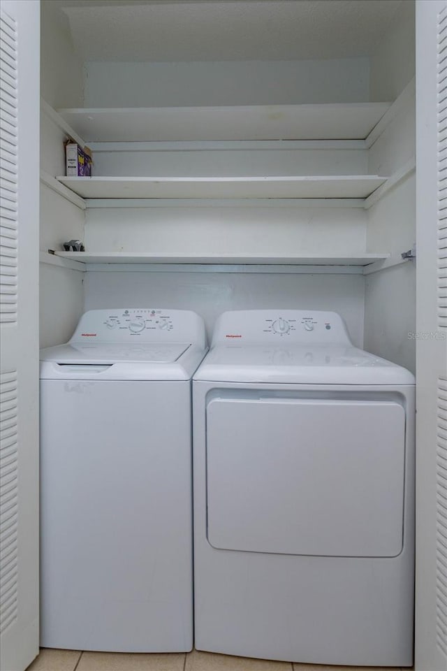 laundry room with light tile patterned floors and washing machine and clothes dryer