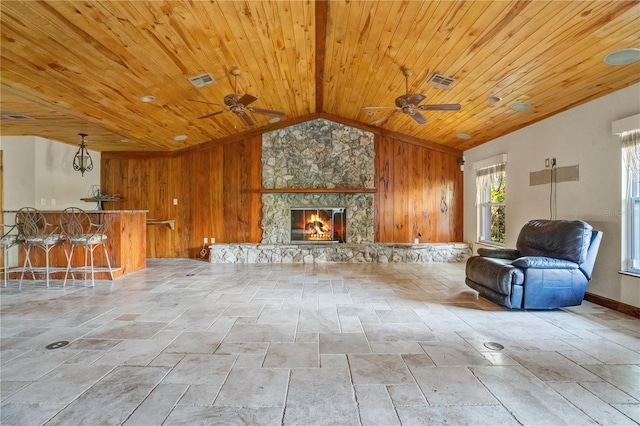 unfurnished living room featuring wooden walls, vaulted ceiling, ceiling fan, a fireplace, and wood ceiling