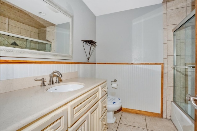 full bathroom featuring combined bath / shower with glass door, tile patterned floors, vanity, wooden walls, and toilet