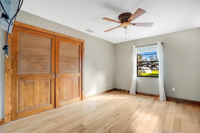 unfurnished bedroom with ceiling fan, a closet, and light hardwood / wood-style floors