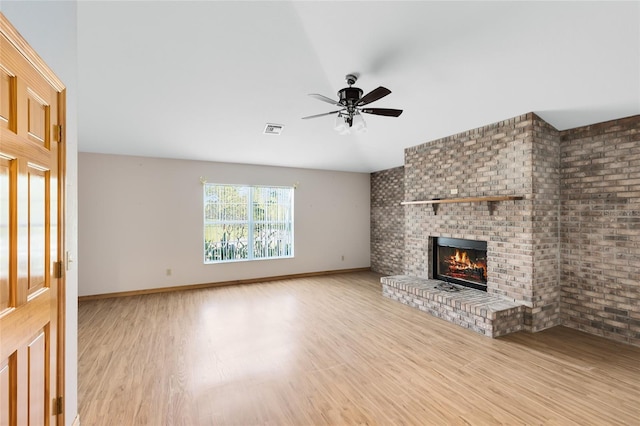 unfurnished living room with ceiling fan, a fireplace, and light hardwood / wood-style flooring