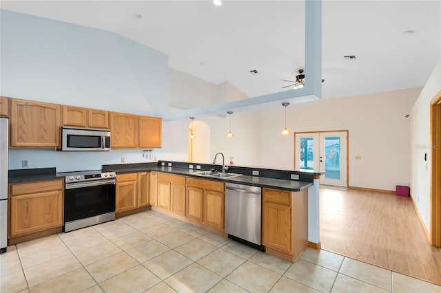 kitchen featuring pendant lighting, sink, light tile patterned floors, stainless steel appliances, and kitchen peninsula