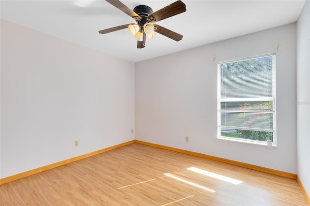 spare room featuring wood-type flooring, a healthy amount of sunlight, and ceiling fan