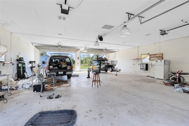 garage featuring white refrigerator and a garage door opener