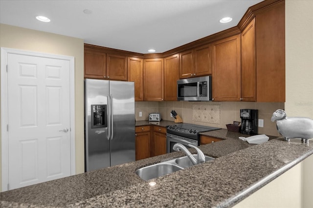 kitchen featuring kitchen peninsula, stainless steel appliances, sink, and decorative backsplash