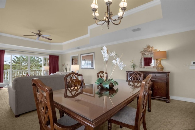 dining space featuring a raised ceiling, light carpet, and crown molding