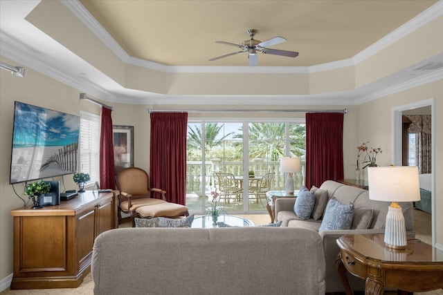 living room with a raised ceiling, ceiling fan, and crown molding