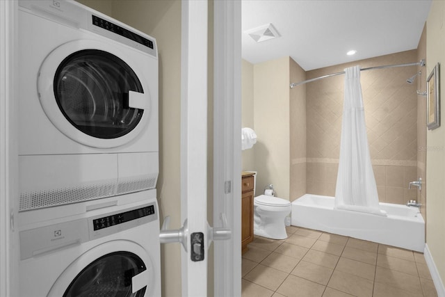 laundry room with light tile patterned flooring and stacked washer / dryer