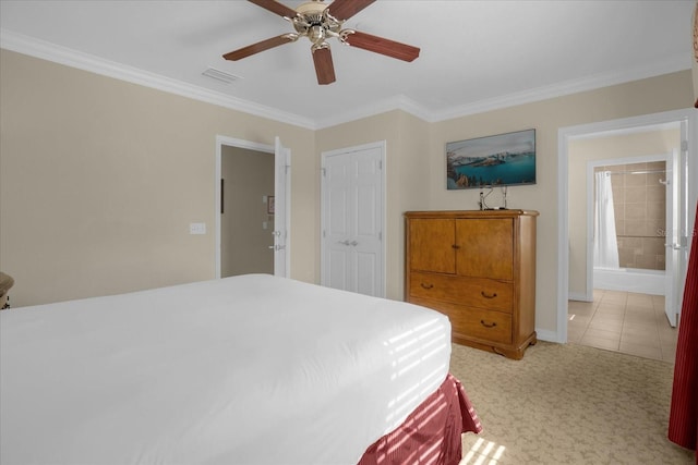 bedroom featuring a closet, crown molding, ensuite bath, light tile patterned floors, and ceiling fan