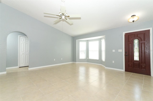 foyer entrance with lofted ceiling, light tile patterned floors, and ceiling fan