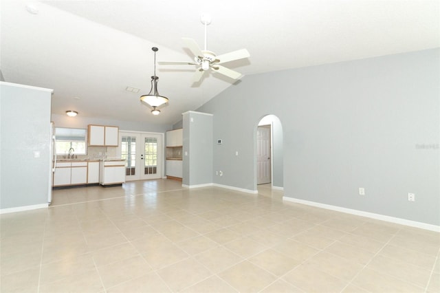 unfurnished living room with light tile patterned flooring, ceiling fan, vaulted ceiling, and sink