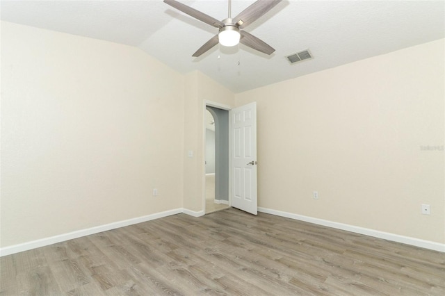 unfurnished room with light wood-type flooring, ceiling fan, and vaulted ceiling