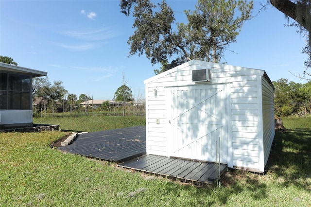 view of outbuilding with a sunroom and a yard