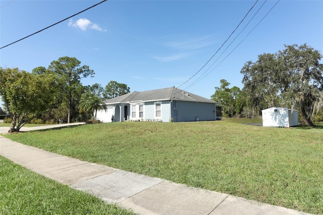 view of front of property with a front yard and a storage shed