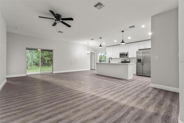 unfurnished living room with hardwood / wood-style floors, sink, and ceiling fan