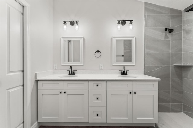 bathroom featuring tiled shower and vanity