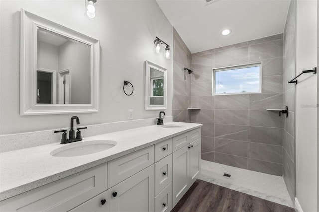 bathroom with vanity, hardwood / wood-style floors, and a tile shower