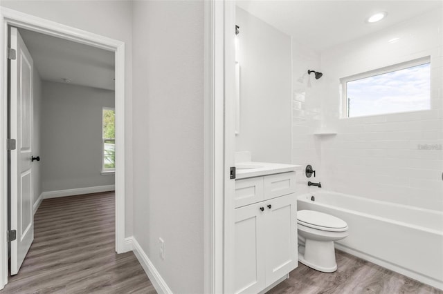 full bathroom with tiled shower / bath combo, vanity, wood-type flooring, and plenty of natural light