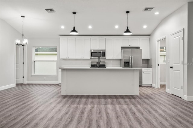 kitchen featuring light hardwood / wood-style flooring, appliances with stainless steel finishes, and white cabinets