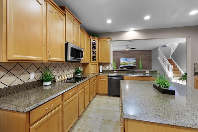 kitchen featuring black appliances, stone counters, decorative backsplash, sink, and ceiling fan