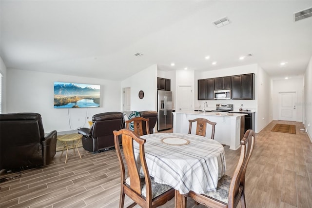 dining room with sink and light hardwood / wood-style flooring