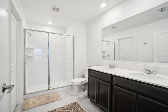 bathroom with vanity, toilet, and a shower with shower door