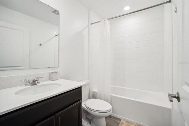 full bathroom with hardwood / wood-style floors, shower / tub combo with curtain, vanity, and toilet