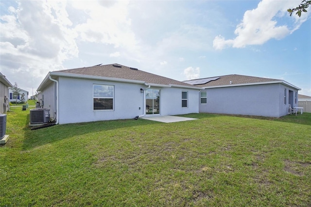 rear view of property with a yard, a patio, and central AC