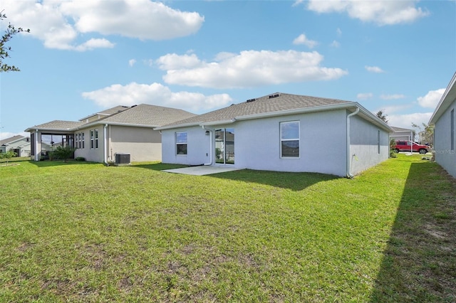 rear view of house with central AC unit, a patio, and a lawn