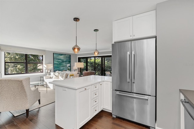 kitchen with stainless steel refrigerator, white cabinetry, dark hardwood / wood-style floors, kitchen peninsula, and decorative light fixtures