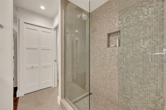 bathroom featuring tile patterned floors and a shower with shower door