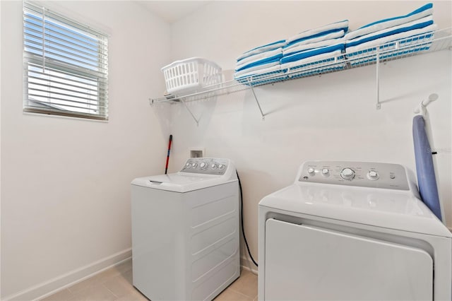 washroom featuring light tile patterned floors and washer and clothes dryer