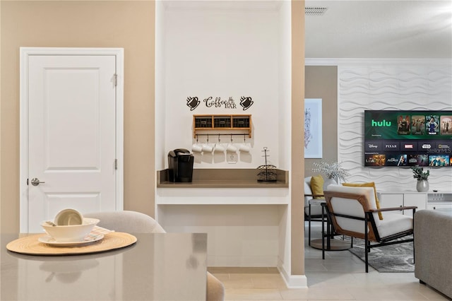 bar featuring light tile patterned flooring and crown molding