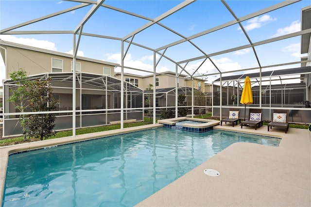 view of pool featuring glass enclosure and an in ground hot tub