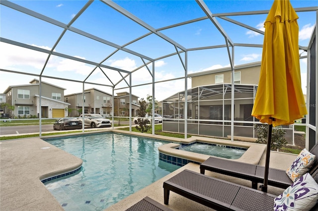 view of swimming pool featuring glass enclosure, an in ground hot tub, and a patio area