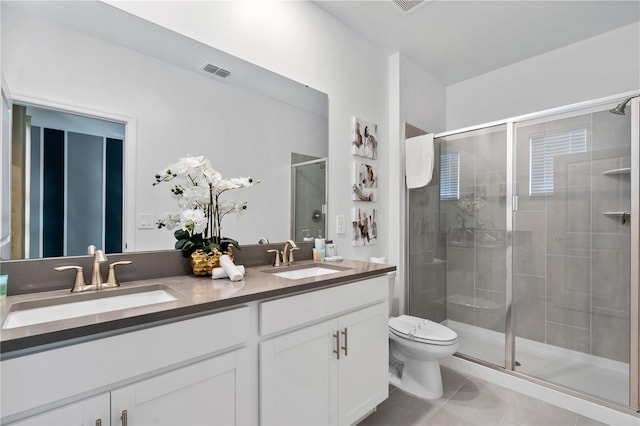 bathroom featuring tile patterned flooring, vanity, toilet, and a shower with door