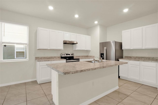 kitchen with sink, appliances with stainless steel finishes, light tile patterned floors, an island with sink, and white cabinets