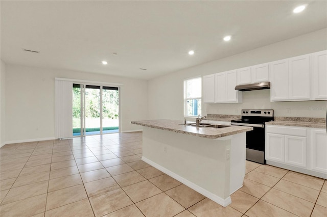 kitchen featuring white cabinets, plenty of natural light, stainless steel range with electric cooktop, and an island with sink