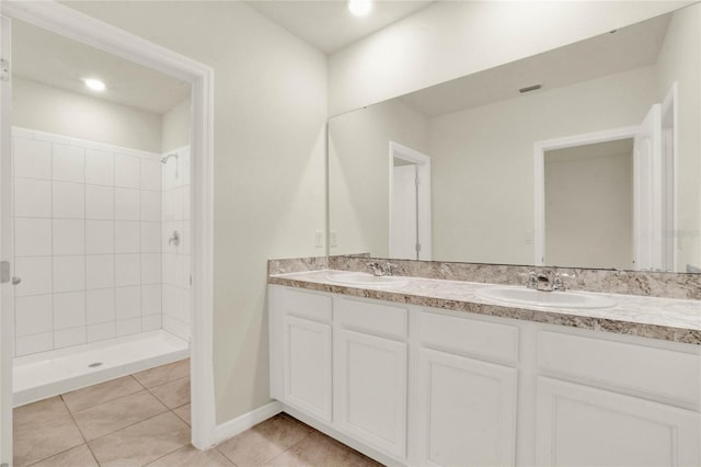 bathroom featuring vanity, tile patterned floors, and tiled shower