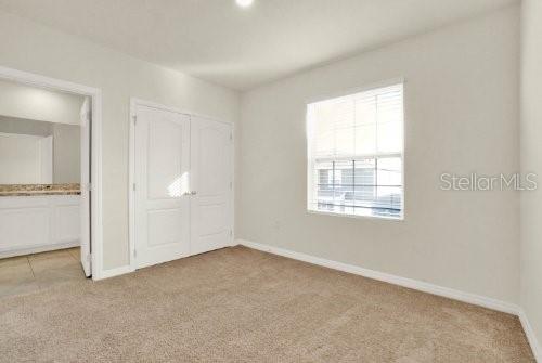 unfurnished bedroom featuring a closet and light carpet