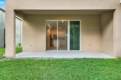 rear view of property featuring a patio area and a yard