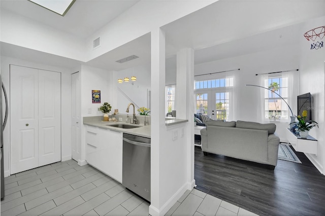 kitchen with french doors, sink, light hardwood / wood-style flooring, stainless steel dishwasher, and white cabinetry