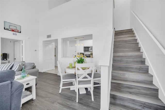 stairway with a high ceiling and hardwood / wood-style flooring