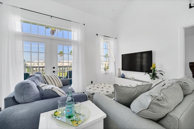 living room featuring high vaulted ceiling and french doors